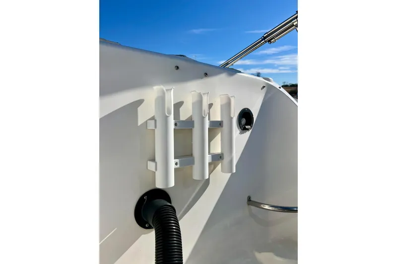 Slide: The Image of 2013 Hurricane SunDeck Sport 220 OB boat interior with rod holders and blue sky. - 12