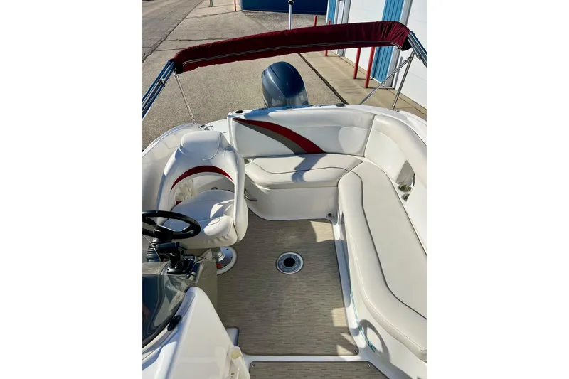 Slide: The Image of 2013 Hurricane SunDeck Sport 220 OB boat interior with seating and steering wheel. - 14