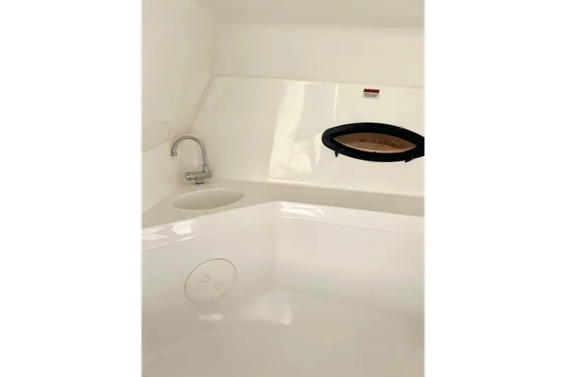 Slide: The Image of Interior view of 2013 Hurricane SunDeck Sport 220 OB boat, featuring a sink and porthole. - 36