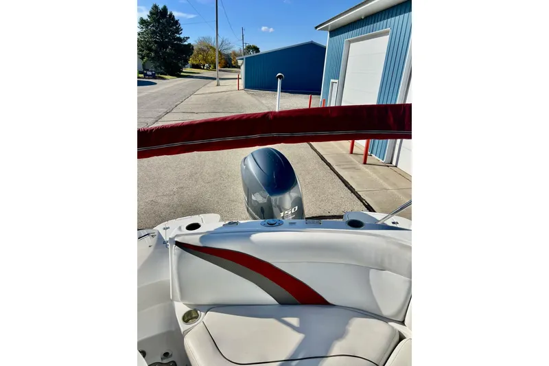 Slide: The Image of 2013 Hurricane SunDeck Sport 220 OB boat with Yamaha 150 engine, parked near blue building. - 63