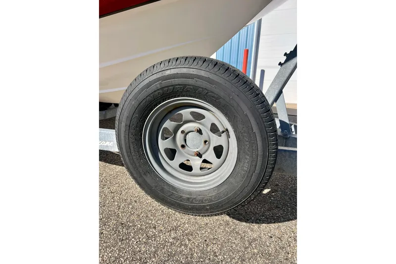 Slide: The Image of Trailer tire of a 2013 Hurricane SunDeck Sport 220 OB boat on pavement. - 7