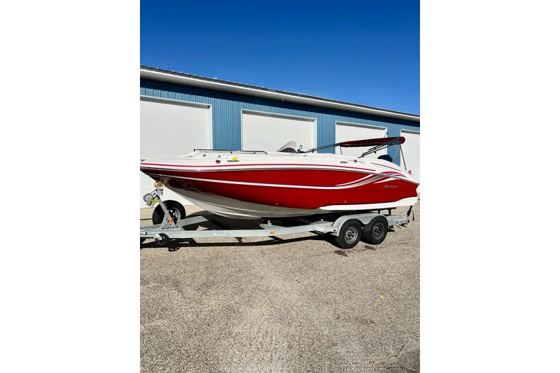 Slide: The Image of 2013 Hurricane SunDeck Sport 220 OB boat on trailer, red and white, parked outdoors. - 71