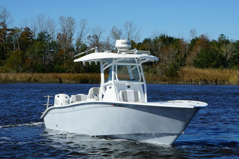 Slide: The Image of 2018 Cape Horn 24 XS boat cruising on a calm river with trees in the background. - 12
