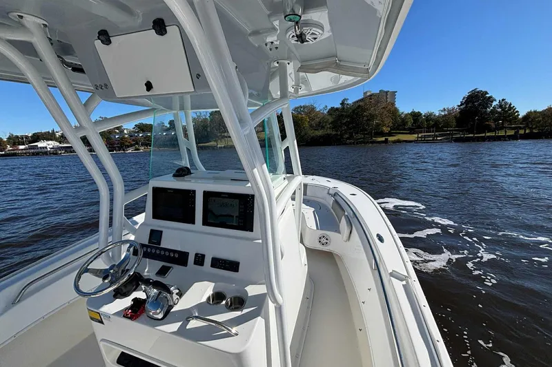 Slide: The Image of 2018 Cape Horn 24 XS boat on a calm river, featuring a modern helm and clear skies. - 19
