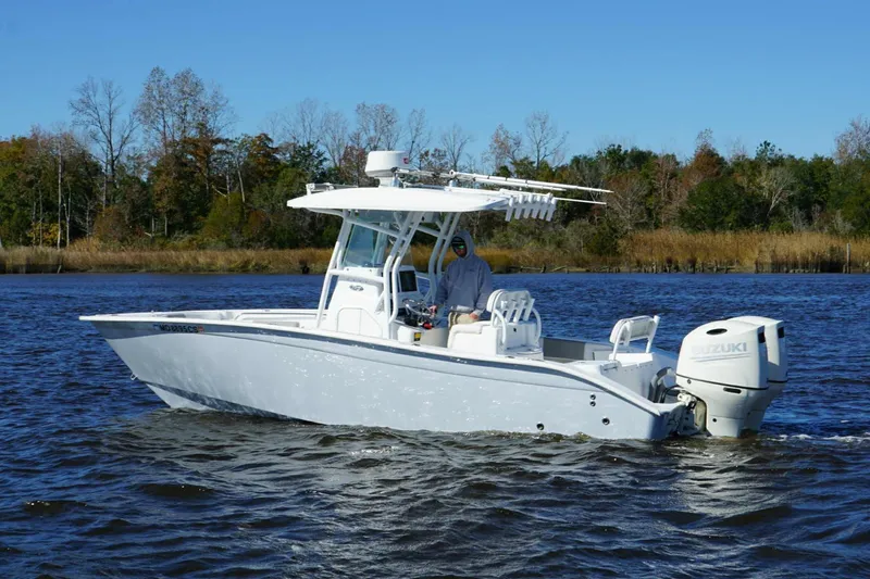 Slide: The Image of 2018 Cape Horn 24 XS boat cruising on a calm river with trees in the background. - 2
