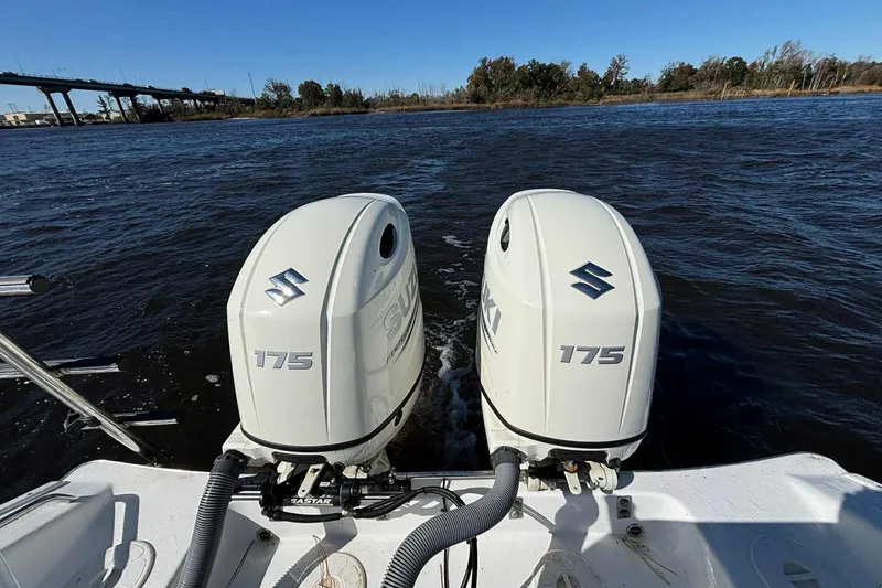 Slide: The Image of Twin Suzuki 175 outboard engines on a 2018 Cape Horn 24 XS boat, cruising on a river. - 25