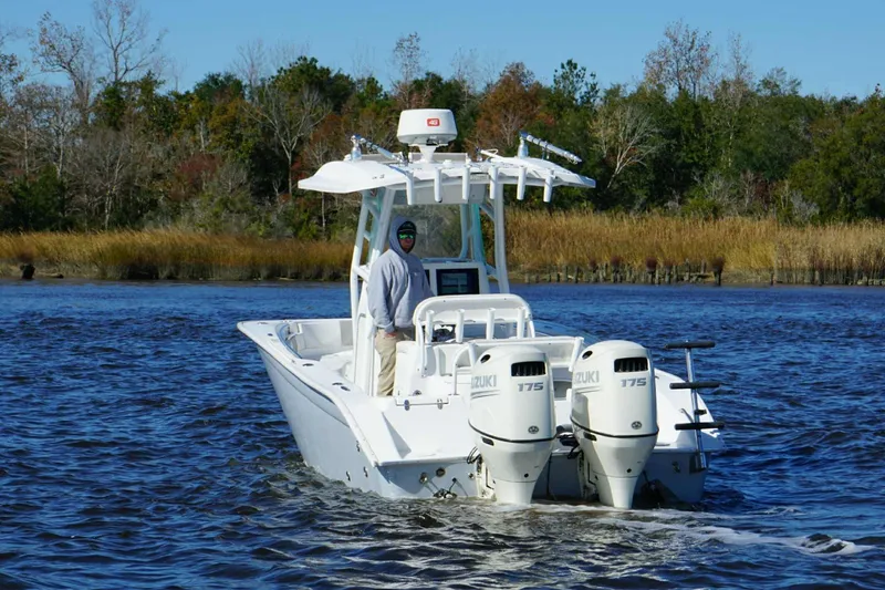 Slide: The Image of 2018 Cape Horn 24 XS boat cruising on a calm river with dual Suzuki engines. - 8