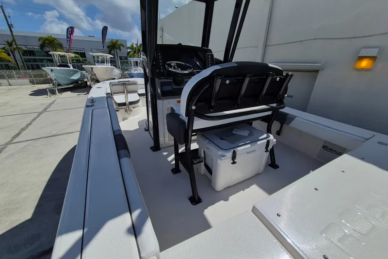 Slide: The Image of 2026 Robalo 246 Cayman boat interior with seating and console, parked outdoors. - 16