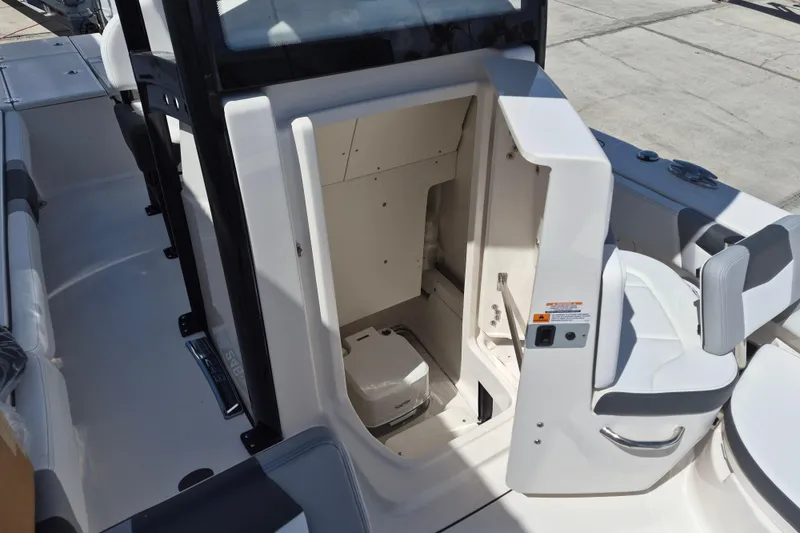 Slide: The Image of 2026 Robalo 246 Cayman boat interior with open storage compartment and seating area. - 19