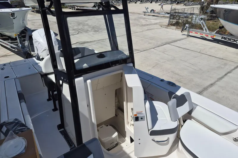 Slide: The Image of 2026 Robalo 246 Cayman boat interior with seating and console, docked outdoors. - 20
