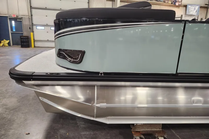 Slide: The Image of 2026 Avalon LSZ Cruise Rear Bench pontoon boat in a warehouse setting. - 12