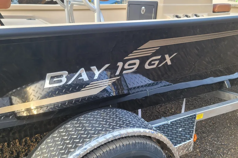 Slide: The Image of 2026 G3 Bay 19 GX boat with sleek black exterior and diamond plate trailer. - 14