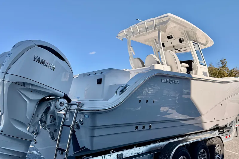 Slide: The Image of 2026 Sea Fox 328 Commander boat with Yamaha engine on trailer, under clear blue sky. - 3
