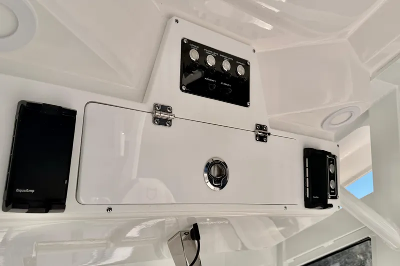 Slide: The Image of 2026 Sea Fox 328 Commander control panel with switches and storage compartment. - 32