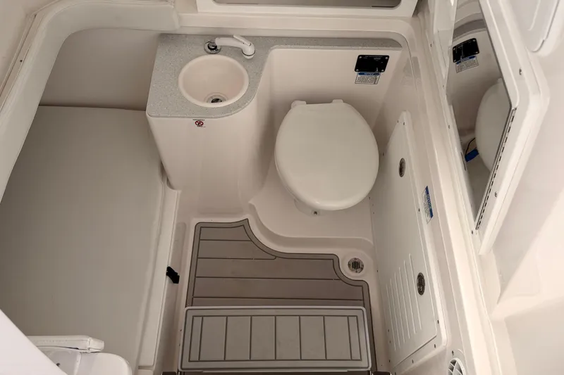 Slide: The Image of 2026 Sea Fox 328 Commander boat bathroom with sink, toilet, and mirror. - 6