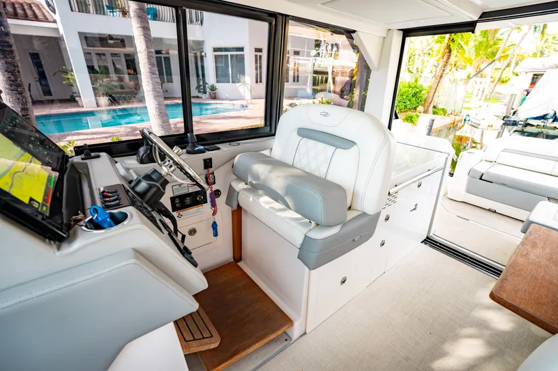 Slide: The Image of Interior of 2022 Regal 36 XO yacht with helm, seating, and poolside view. - 18