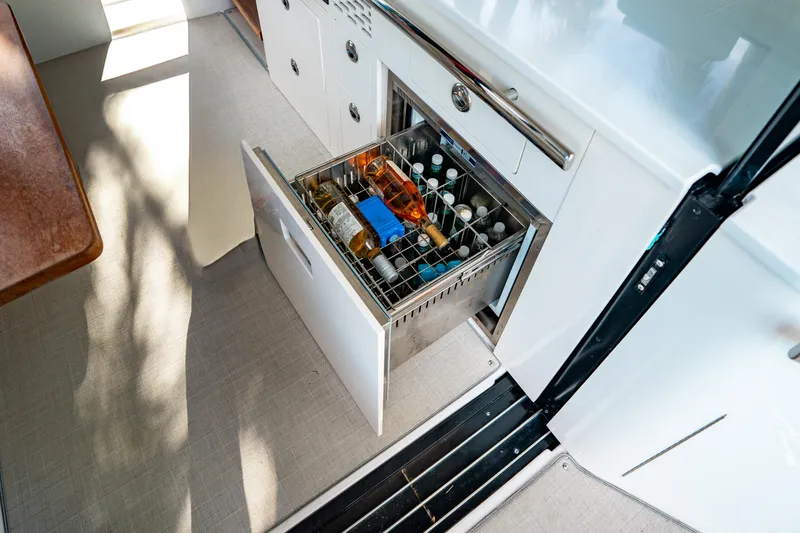 Slide: The Image of 2022 Regal 36 XO yacht interior with open drawer fridge stocked with beverages. - 26