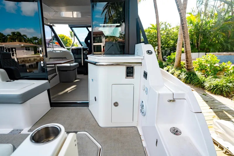 Slide: The Image of 2022 Regal 36 XO boat deck with open hatch and railing, reflecting water. - 37