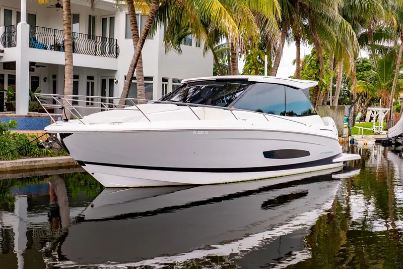 Slide: The Image of 2022 Regal 36 XO yacht docked by a waterfront home with palm trees. - 4