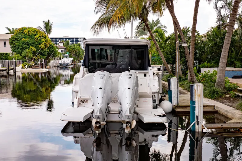 Slide: The Image of 2022 Regal 36 XO boat docked in a tropical canal setting. - 6