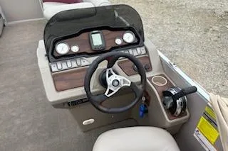 Slide: The Image of 2013 Premier 220 SunSation boat dashboard with steering wheel and controls. - 2