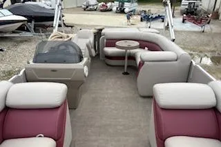 Slide: The Image of 2013 Premier 220 SunSation pontoon boat with spacious seating and table, docked outdoors. - 3