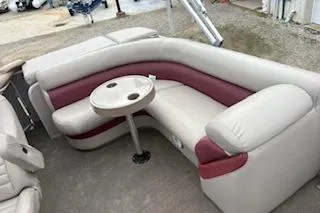 Slide: The Image of 2013 Premier 220 SunSation boat interior with beige and maroon seating and a round table. - 7