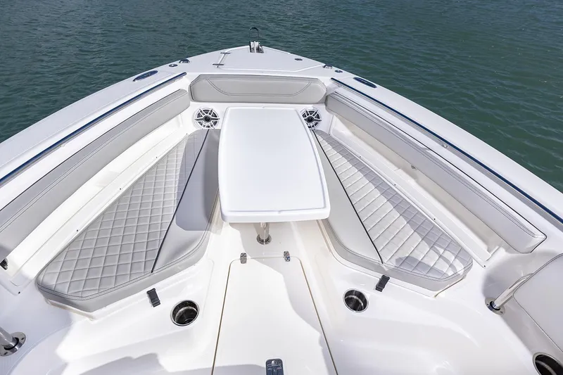 Slide: The Image of Manufacturer Provided Image: 2025 Pursuit S 248 Sport boat interior with cushioned seating and table on water. - 5