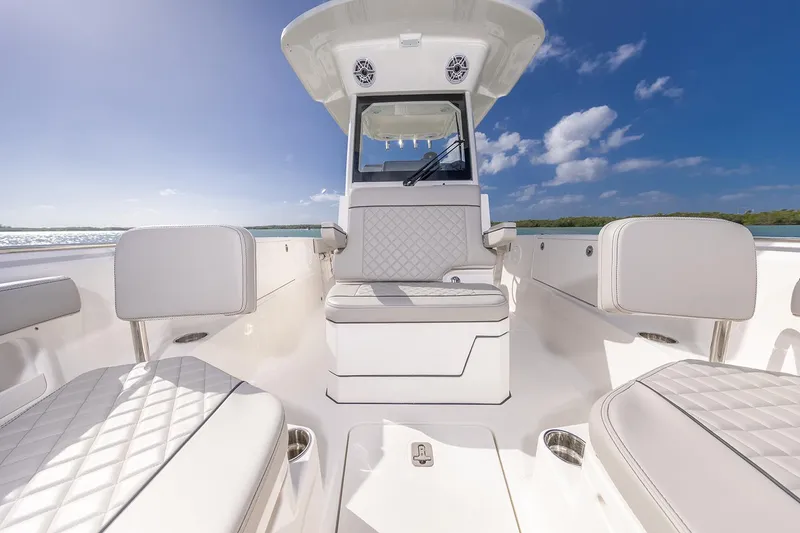 Slide: The Image of Manufacturer Provided Image: 2025 Pursuit S 248 Sport boat interior with white seating, under a clear blue sky. - 8