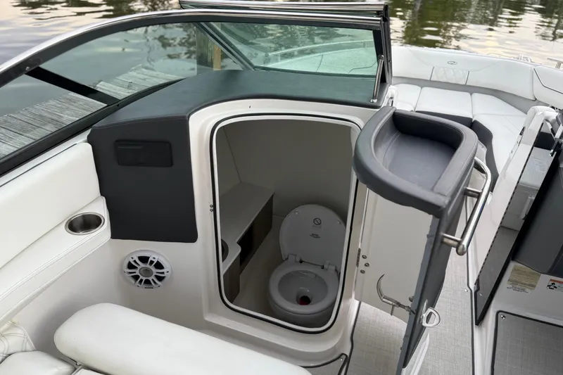 Slide: The Image of 2023 Regal LX4 boat interior with open bathroom door, showcasing compact toilet design. - 12