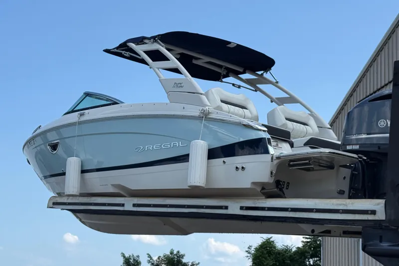 Slide: The Image of 2023 Regal LX4 boat with sleek design and modern features, docked outdoors. - 2