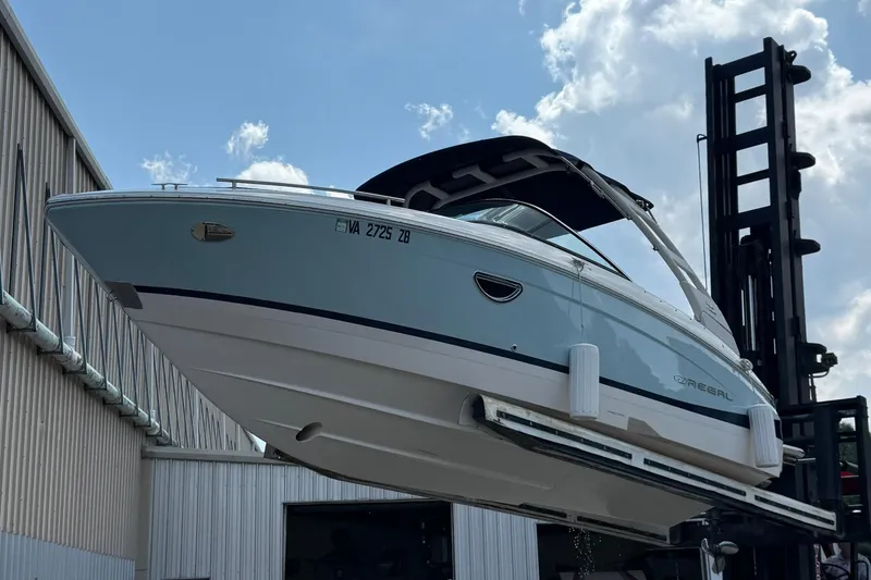 Slide: The Image of 2023 Regal LX4 boat lifted by forklift against a cloudy sky backdrop. - 4