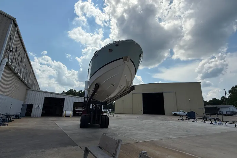 Slide: The Image of 2023 Regal LX4 boat elevated in a shipyard under a cloudy sky. - 5