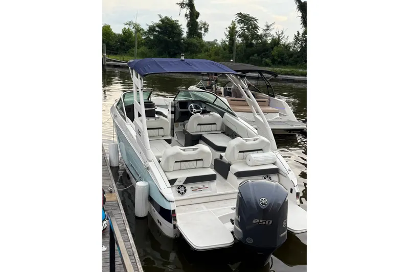 Slide: The Image of 2023 Regal LX4 boat docked, featuring a Yamaha 250 outboard motor and blue canopy. - 6