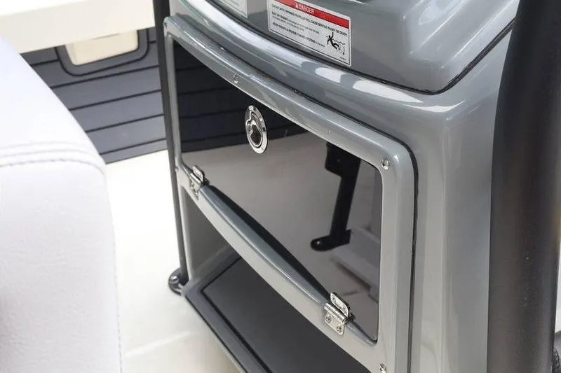 Slide: The Image of 2025 Pathfinder 2200 TRS boat console with storage compartment and safety warning label. - 17
