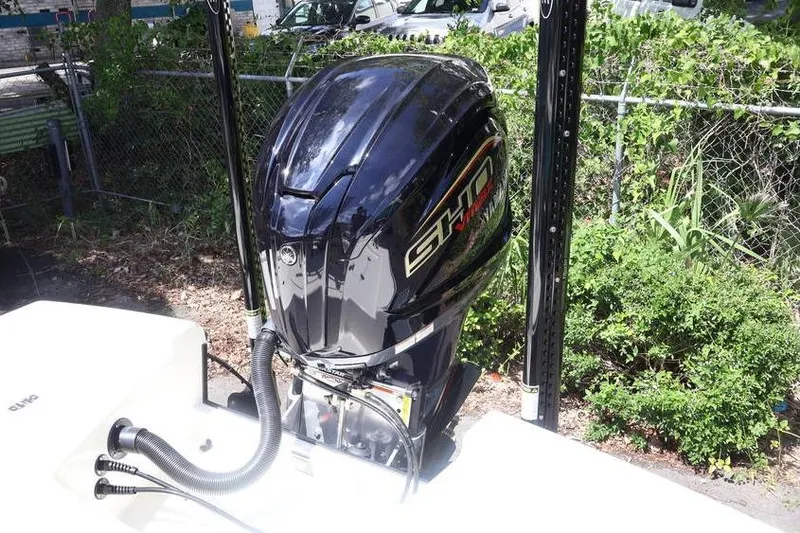 Slide: The Image of 2025 Pathfinder 2200 TRS boat with a powerful outboard motor, parked outdoors. - 23