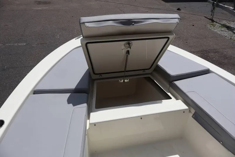 Slide: The Image of 2025 Pathfinder 2200 TRS boat with open storage compartment and cushioned seating. - 6