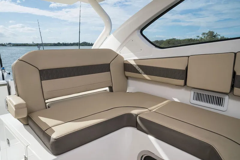 Slide: The Image of Manufacturer Provided Image: 2025 Pursuit DC 365 Dual Console boat interior with beige seating. - 13