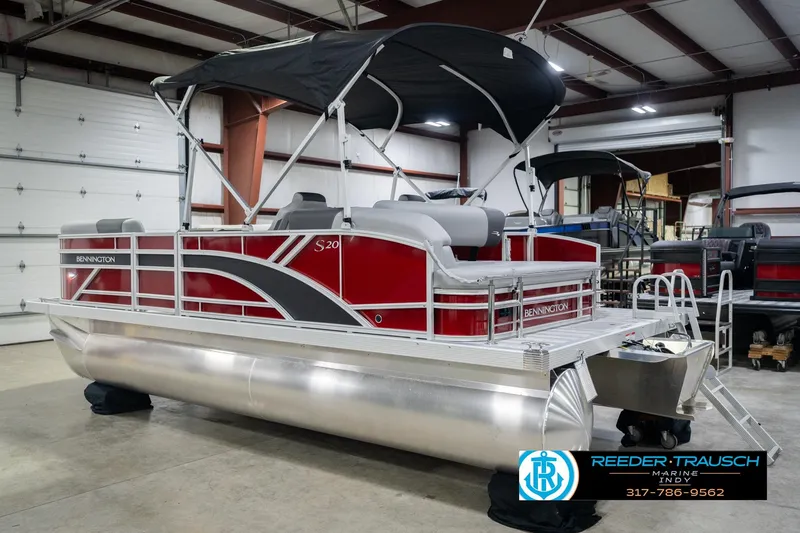 Slide: The Image of 2026 Bennington 20 SSR pontoon boat with red and silver design in a showroom. - 10