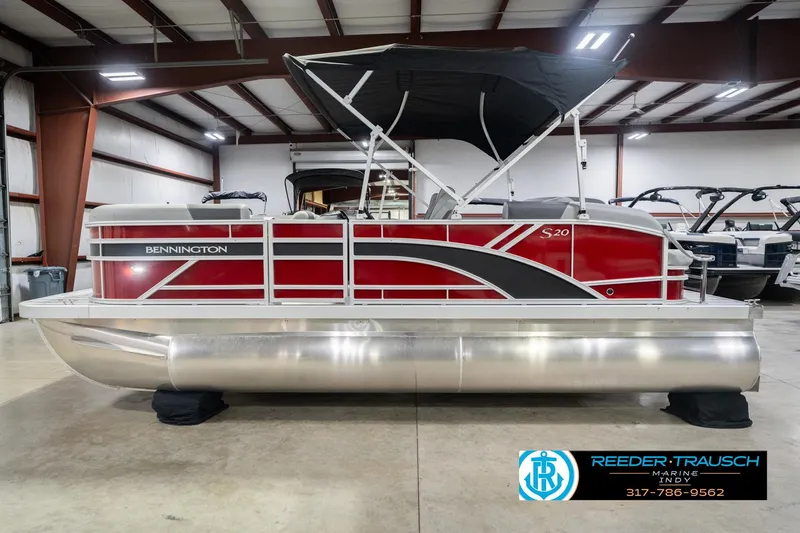 Slide: The Image of 2026 Bennington 20 SSR pontoon boat in showroom, featuring red and silver design. - 11