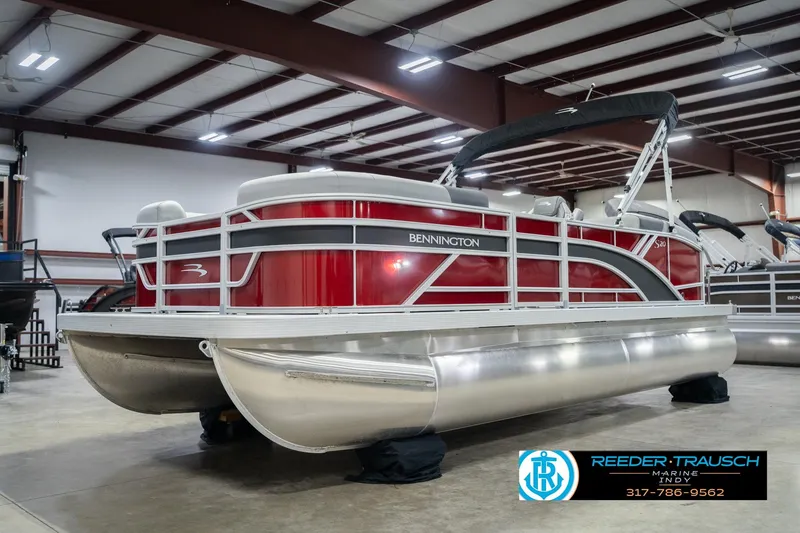 Slide: The Image of 2026 Bennington 20 SSR pontoon boat in showroom, featuring sleek red and silver design. - 3