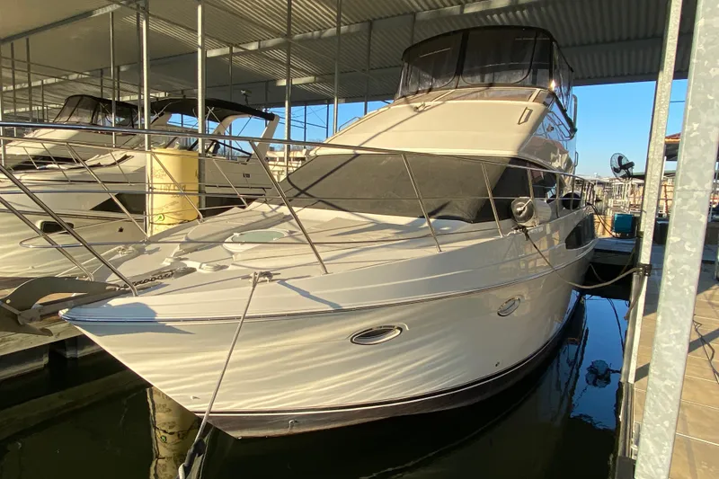 The Image of 2005 Carver 38 Super Sport yacht docked in a marina under a covered slip. - 0