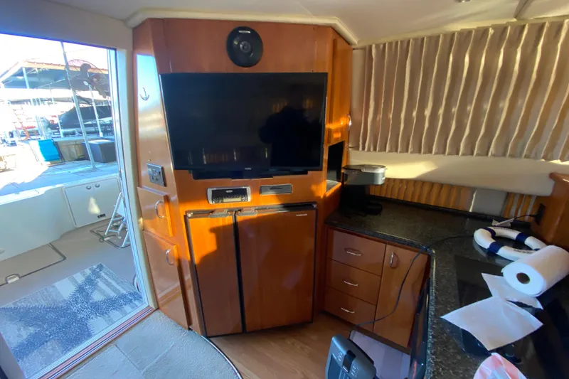 Slide: The Image of 2005 Carver 38 Super Sport yacht interior with sink, seating, and water view. - 10