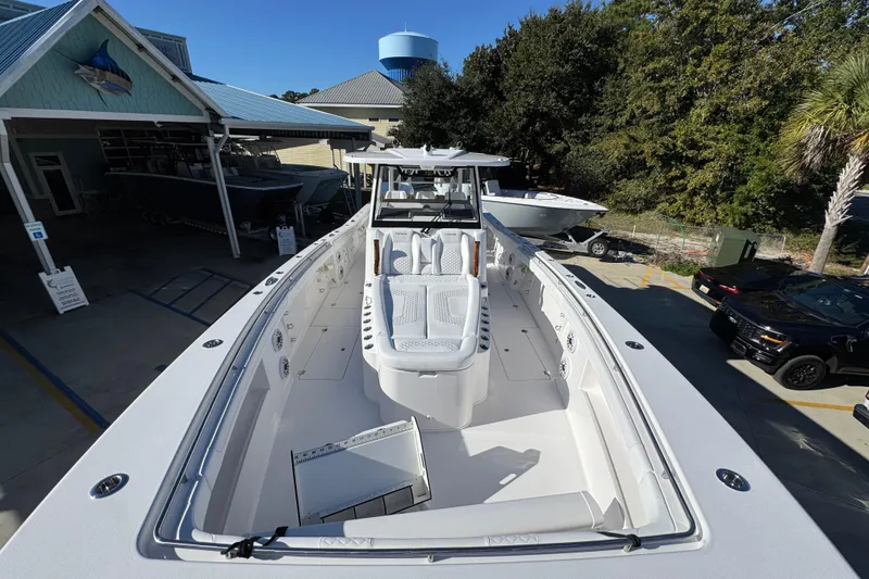 Slide: The Image of 2026 Caymas 44 CT boat with spacious deck and modern design, docked near a marina. - 16