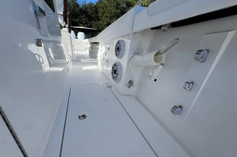Slide: The Image of 2026 Caymas 44 CT boat deck with speakers and hose, surrounded by trees. - 23