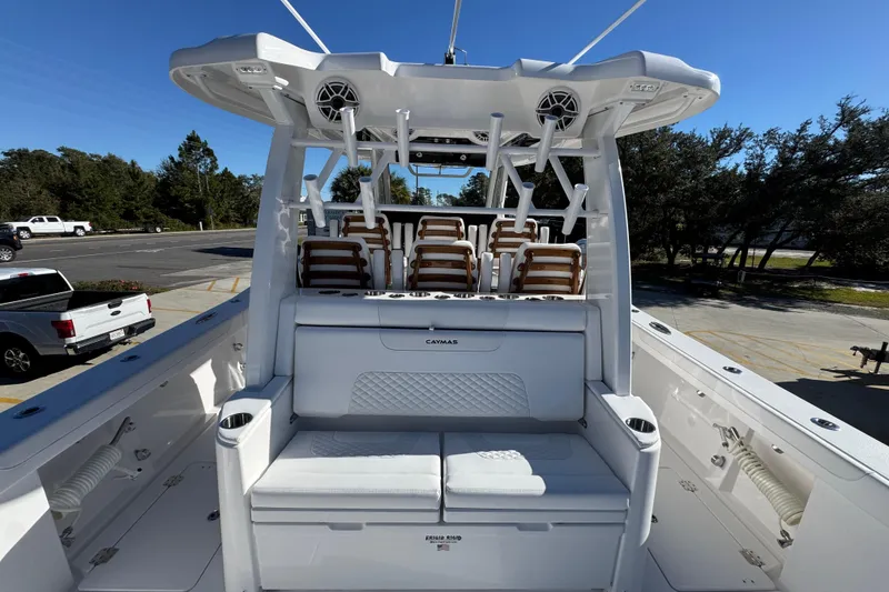 Slide: The Image of 2026 Caymas 44 CT boat interior with seating and rod holders, parked outdoors. - 36
