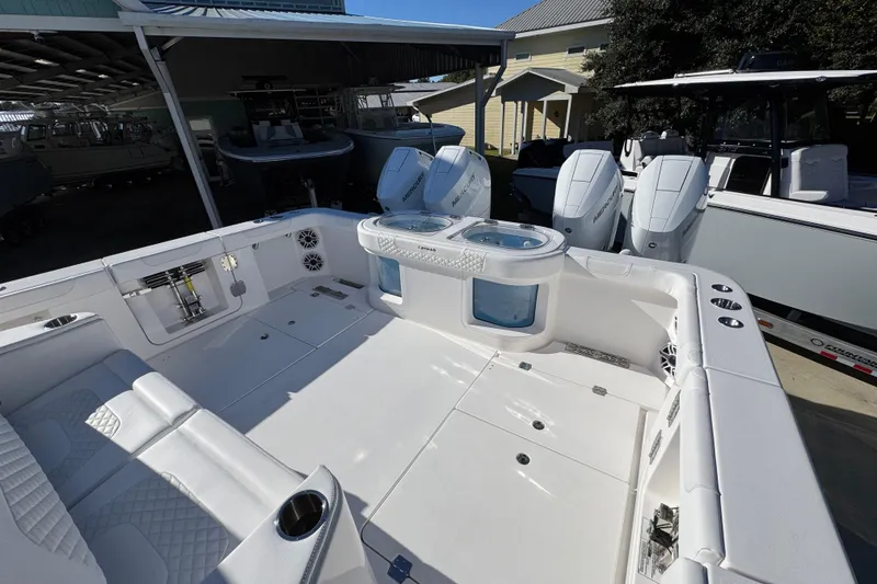Slide: The Image of 2026 Caymas 44 CT boat interior with seating and outboard motors in a marina setting. - 38