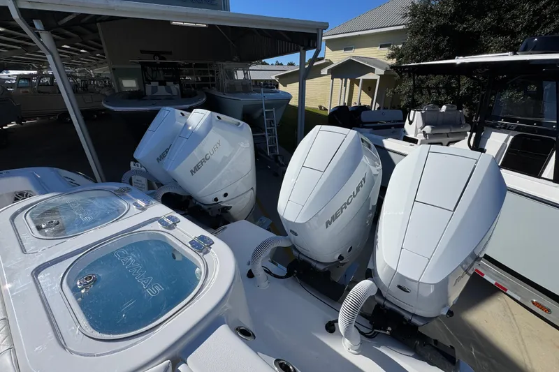Slide: The Image of 2026 Caymas 44 CT boat with triple Mercury outboard engines in a marina. - 43