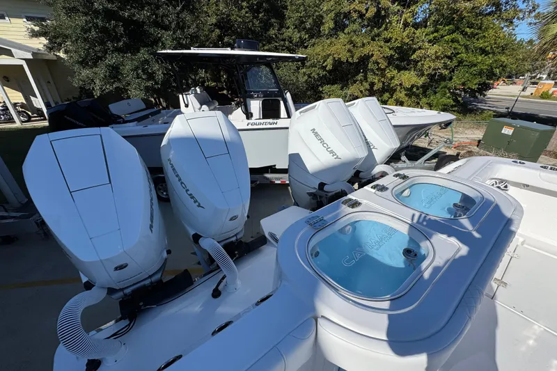 Slide: The Image of 2026 Caymas 44 CT boat with Mercury engines and livewells, parked outdoors. - 44