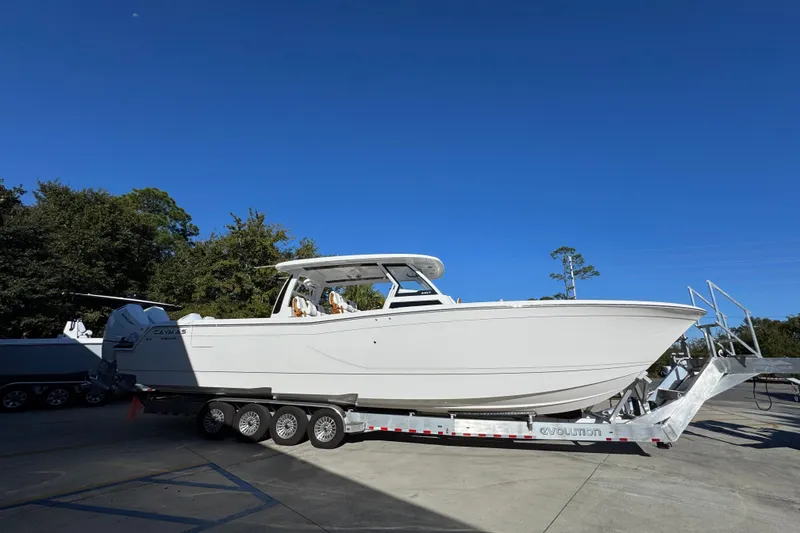 Slide: The Image of 2026 Caymas 44 CT boat on trailer under clear blue sky. - 8